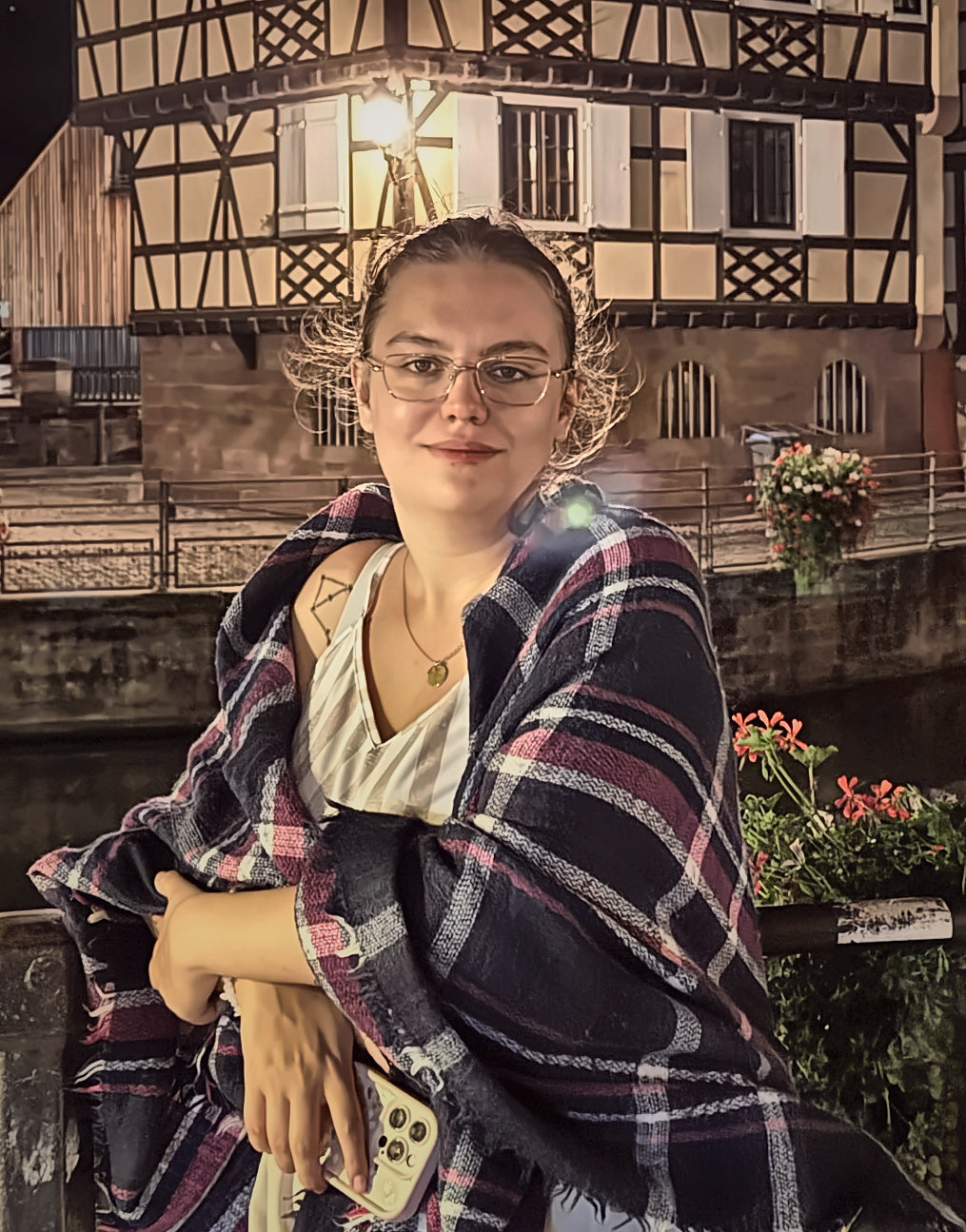 Anastasia, créatrice de Ploutos Bougie, portrait en ambiance nocturne aux tons chauds dans un cadre prune et or